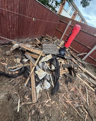 Before: a heap of broken timber and building rubble in a back yard