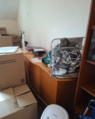 Before: boxes, a desk and a dehumidifier in a flat