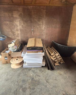 Before: boxes, cable reels and flat-pack stacked in a garage