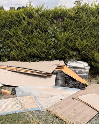 Before: broken fence panels, a barbecue and a toy car piled on gravel